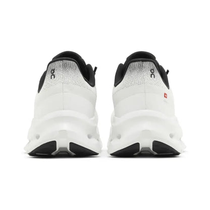 Tênis branco e preto visto de trás, sola robusta, design esportivo, ideal para corrida