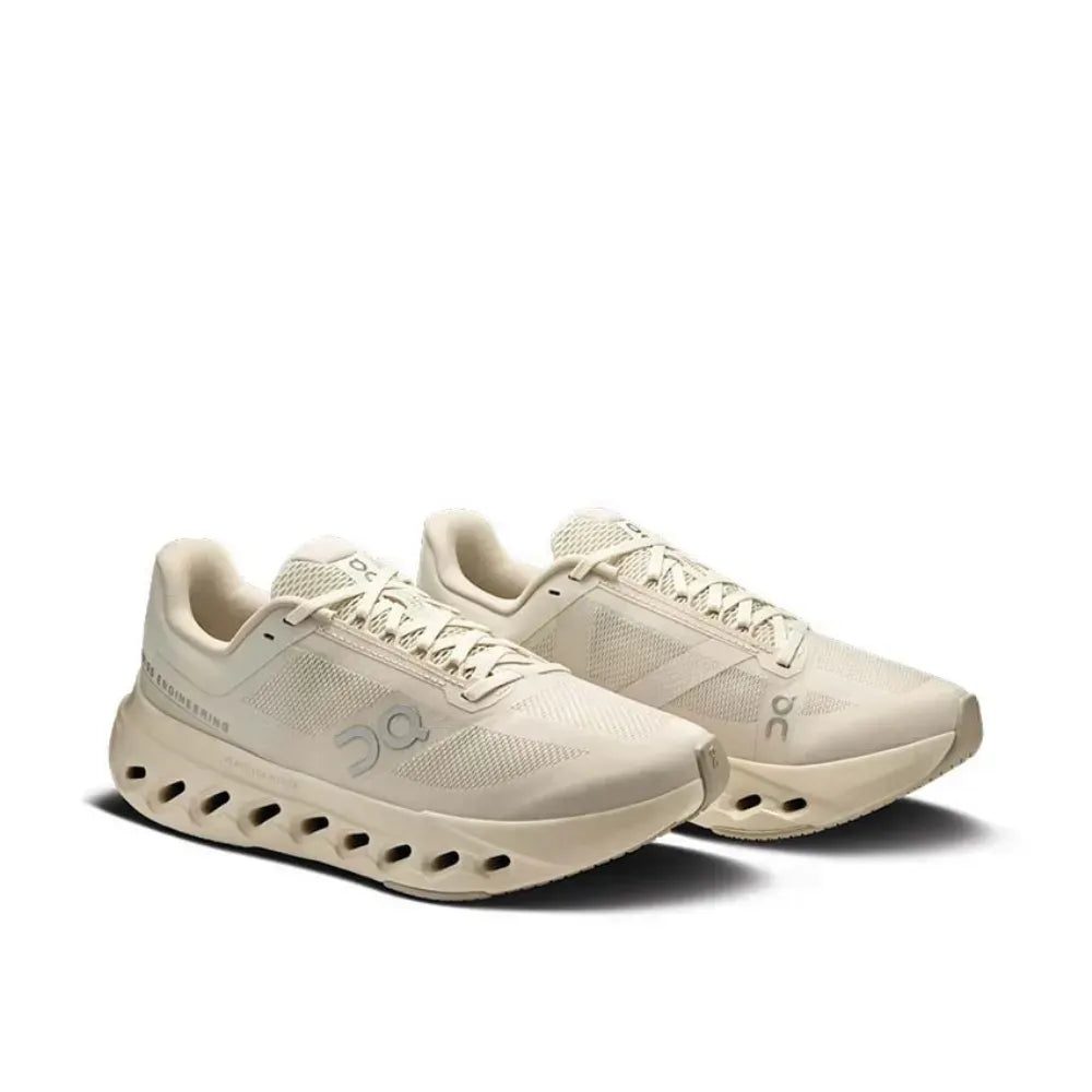 Tênis esportivo bege On Running com design moderno e sola perfurada, fundo branco.