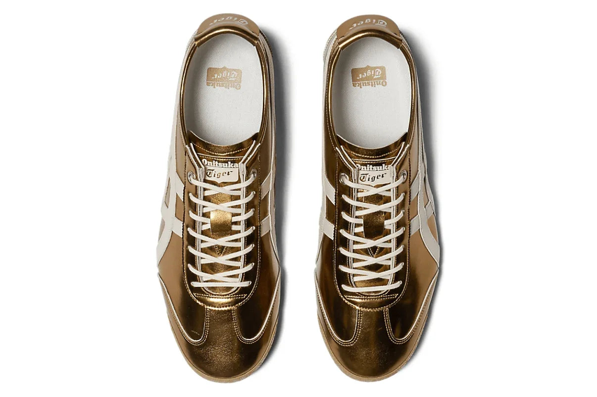 Tênis casual dourado metálico com detalhes brancos, visto de cima, estilo retrô.