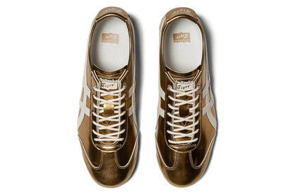 Tênis casual dourado metálico com detalhes brancos, visto de cima, estilo retrô.