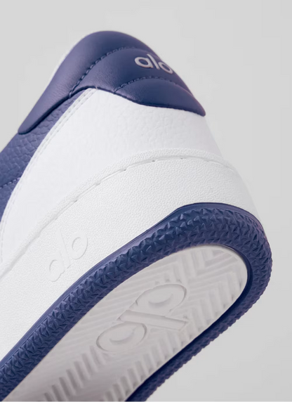 Detalhe do tênis azul e branco Alo Yoga com sola texturizada e logo em relevo