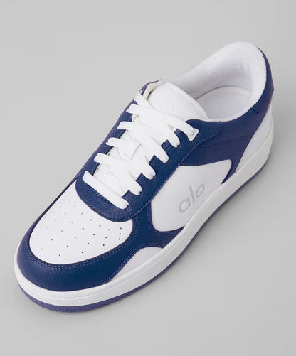 Tênis esportivo branco com detalhes azul escuro, sola branca e logo alo na lateral.