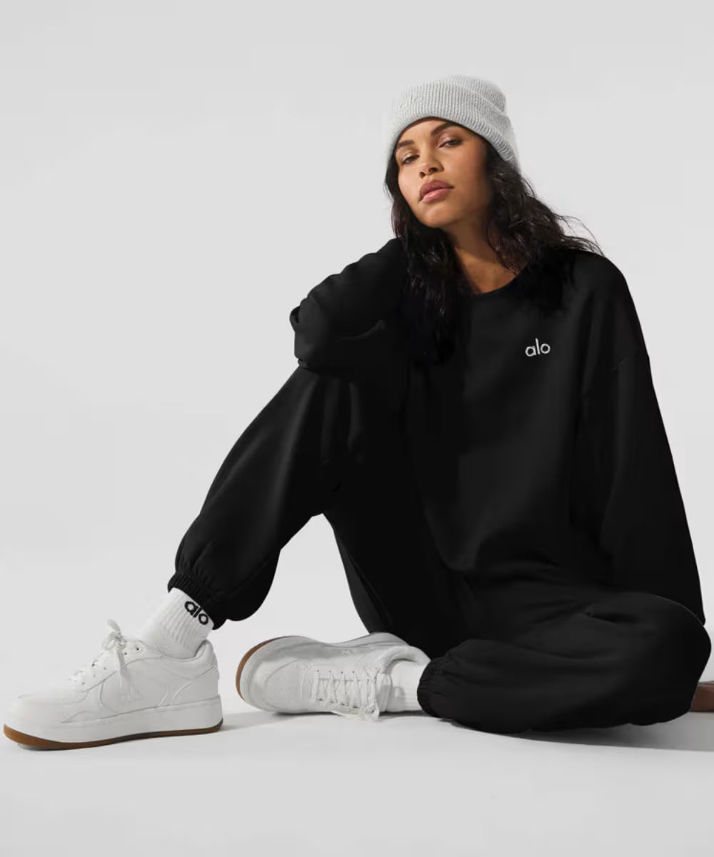 Modelo usando tênis branco marrom alo yoga Recovery Mode, moletom preto e gorro cinza