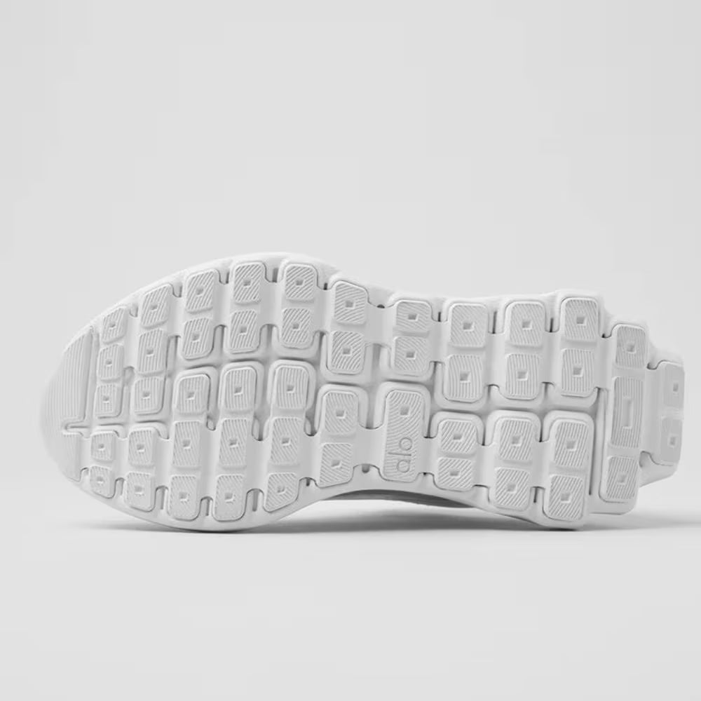 Solado branco de tênis de corrida Alo Yoga com design geométrico e textura antiderrapante.