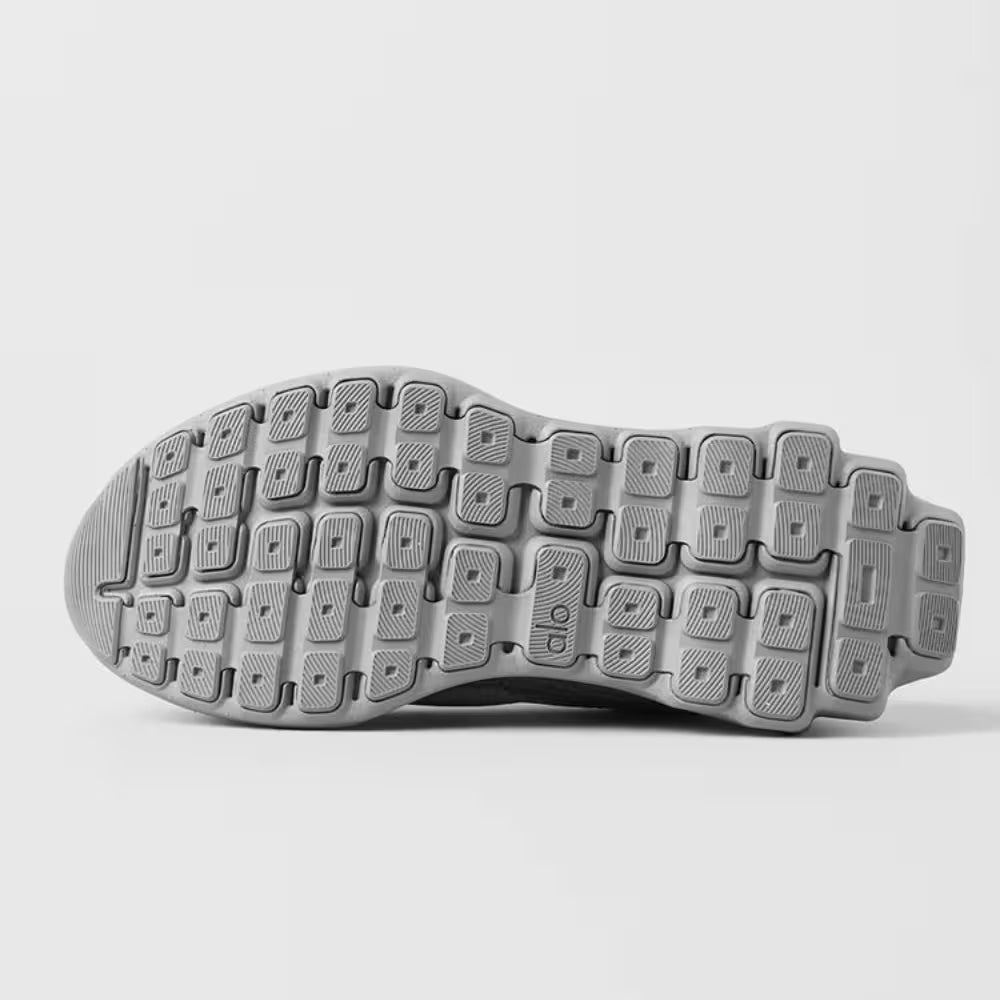 Solado de tênis esportivo cinza, textura antiderrapante e design moderno para corrida.
