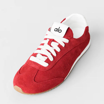 Tênis casual vermelho de camurça, solado branco, marca visível na língua, estilo moderno.
