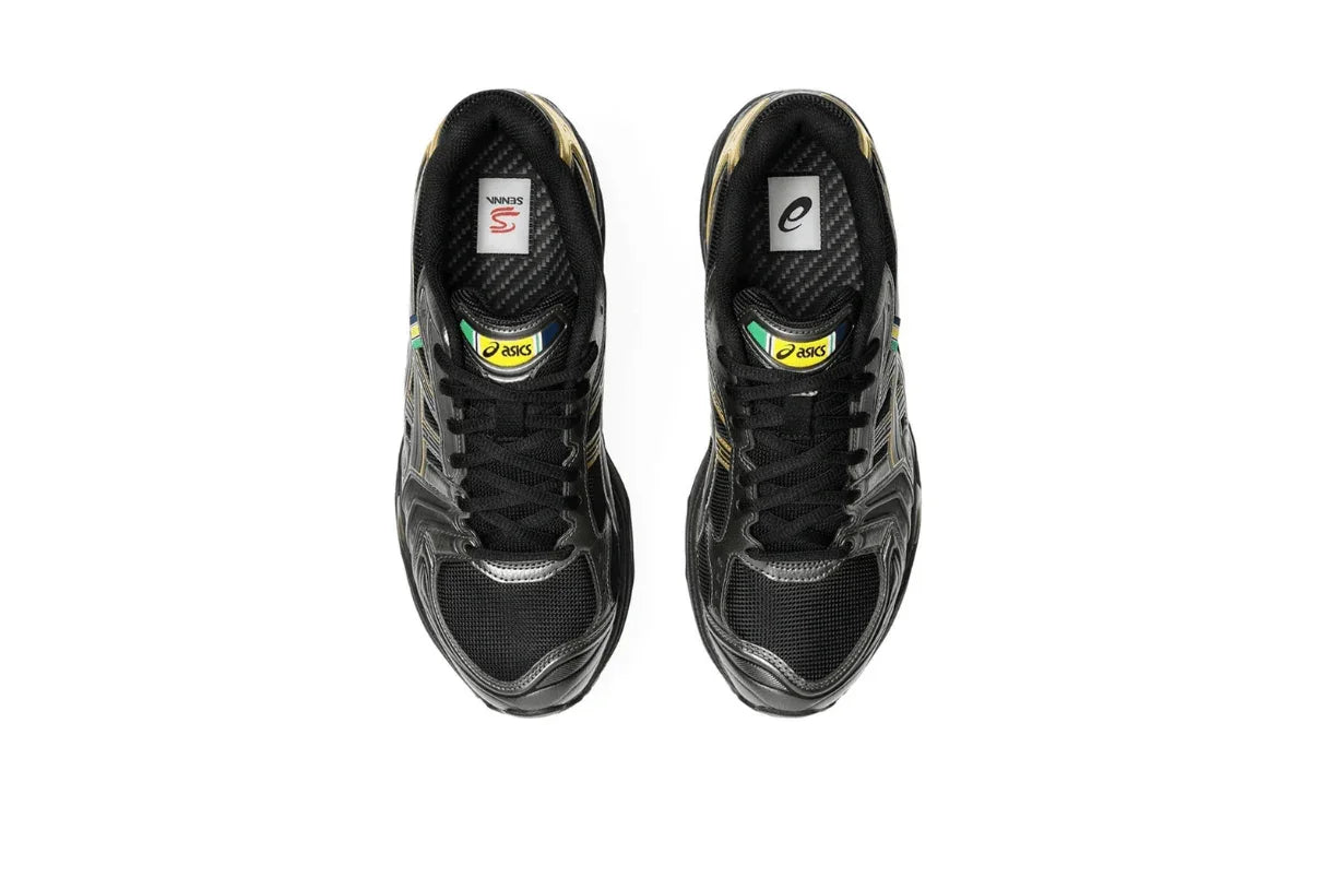 Tênis preto Asics Gel Kayano 14 com detalhes dourados, visualizado de cima, design esportivo.