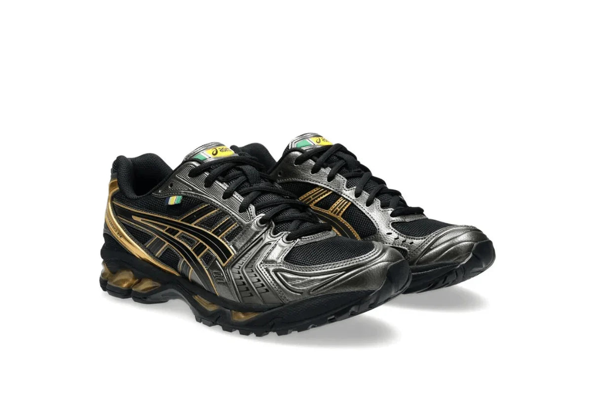 Tênis esportivo preto e dourado com detalhes metálicos, design moderno e sola robusta.