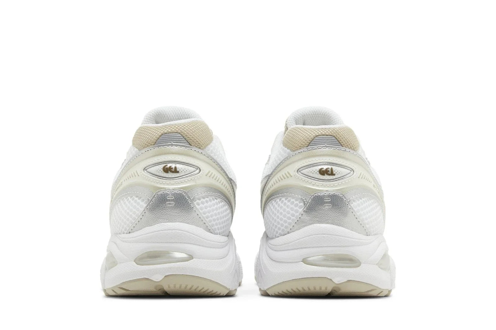 Tênis branco com detalhes bege e prata, sola robusta, vistos por trás, estilo esportivo moderno.
