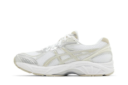 Tênis branco esportivo com detalhes bege, visual moderno e solado robusto, fundo branco.