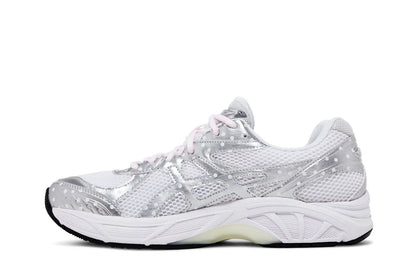 Tênis esportivo branco com detalhes prateados, design de mesh e sola robusta, em fundo branco.