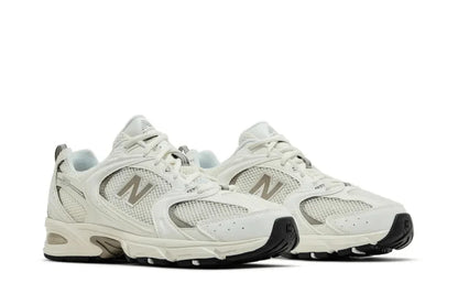 Tênis casual branco e cinza com detalhes em mesh e solado robusto, visual moderno.