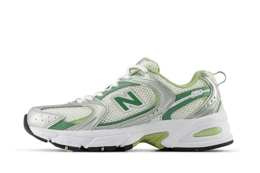 Tênis casual branco com detalhes verdes, solado robusto e design esportivo moderno.