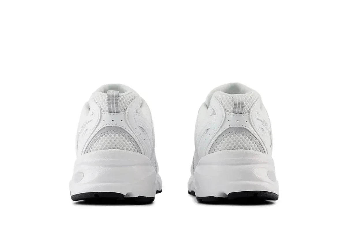 Tênis branco esportivo visto de trás, com detalhes em mesh e solado robusto.