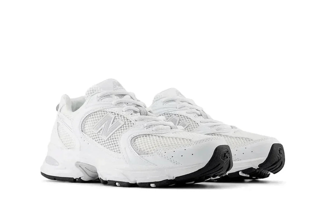 Tênis esportivo branco com detalhes em cinza e sola preta, design moderno e versátil