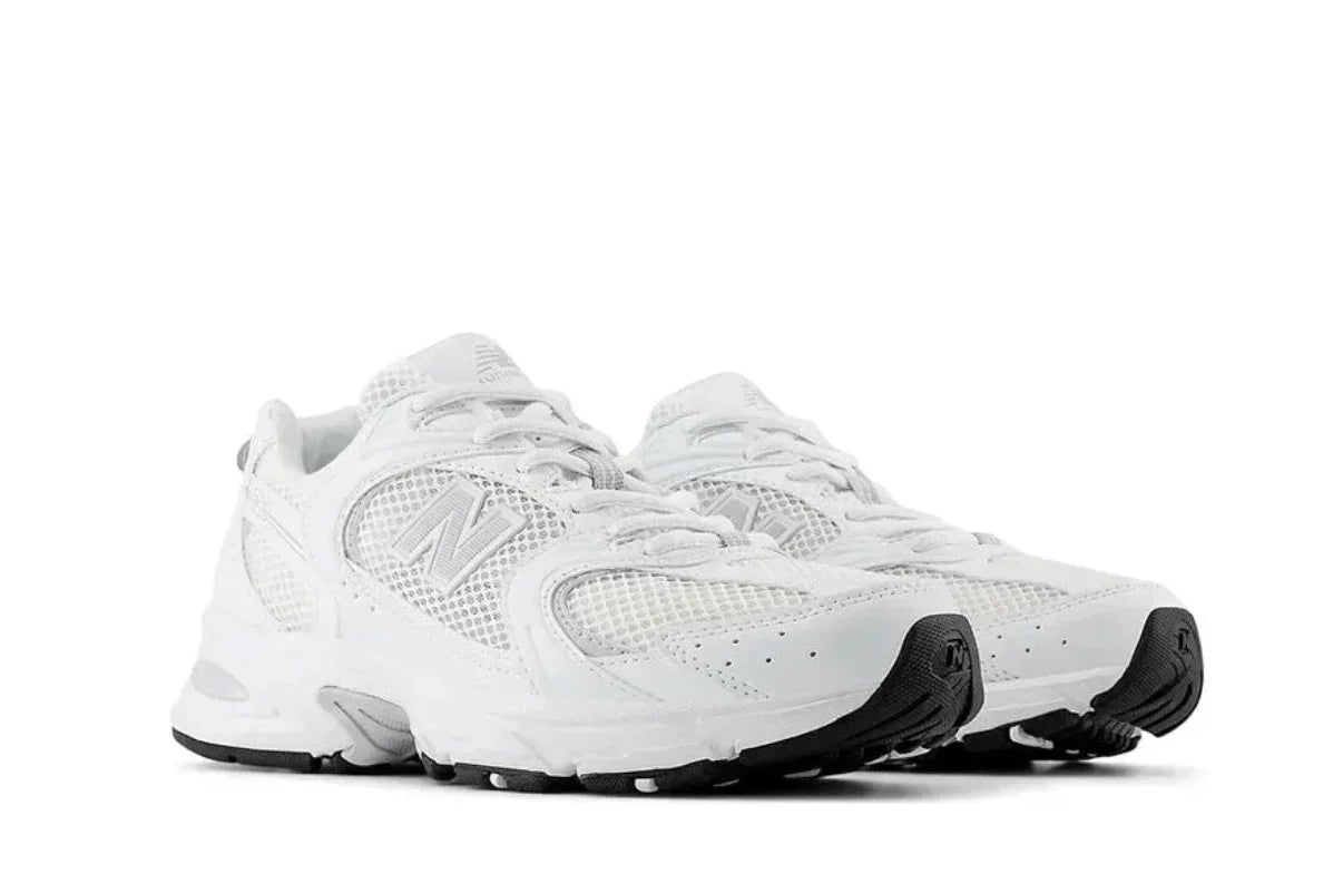 Tênis esportivo branco com detalhes em cinza e sola preta, design moderno e versátil