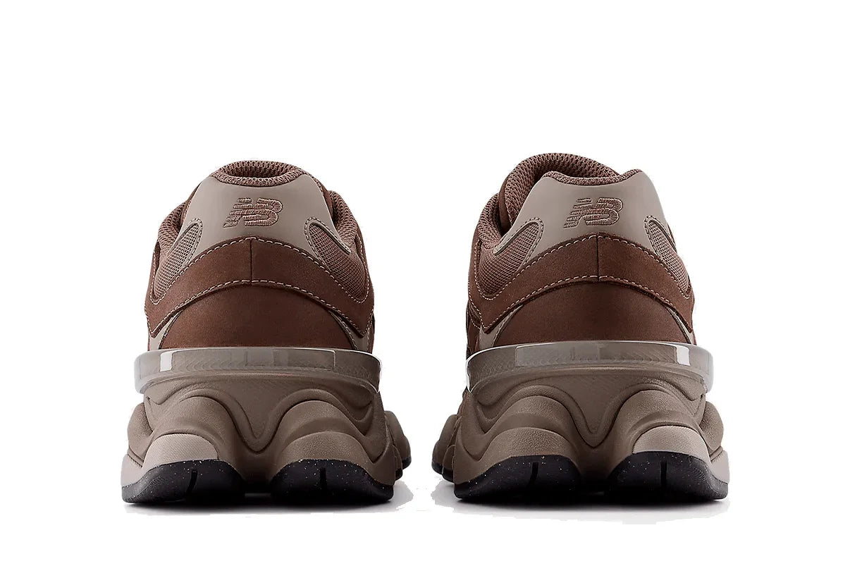Tênis marrom New Balance 9060 visto de trás, solado robusto e detalhes em bege.