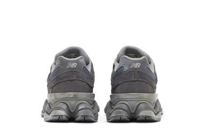 Tênis cinza New Balance 9060 visto por trás, com solado robusto e detalhes em camurça.
