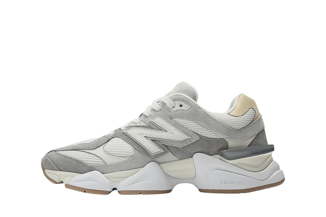Tênis esportivo masculino cinza e branco com detalhes em mesh e solado robusto.