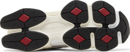 Solado do tênis esportivo cinza com detalhes pretos e vermelhos, estilo moderno.
