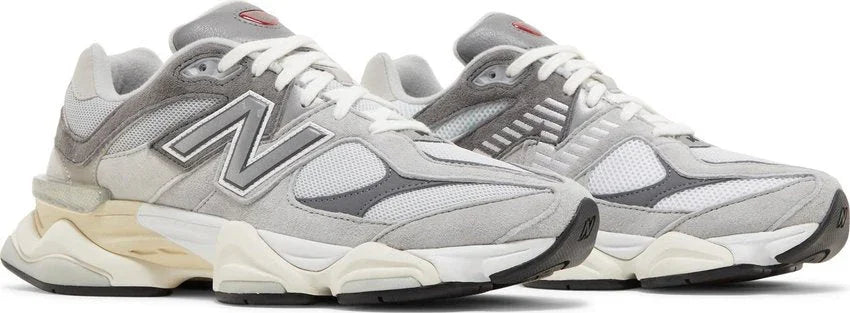 Tênis esportivo cinza e branco com detalhes em mesh e solado robusto, estilo casual, fundo branco.