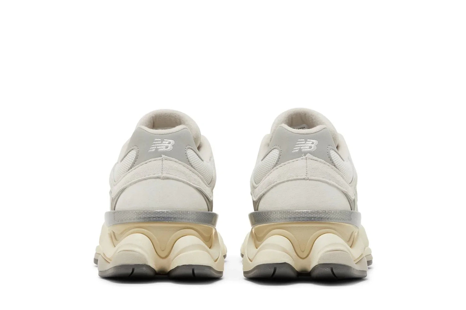 Tênis branco New Balance 9060 vistos de trás, com solado robusto bege e cinza, detalhes em camurça.