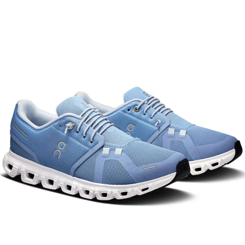 Tênis esportivo azul com sola branca, design moderno e malha respirável, vista lateral
