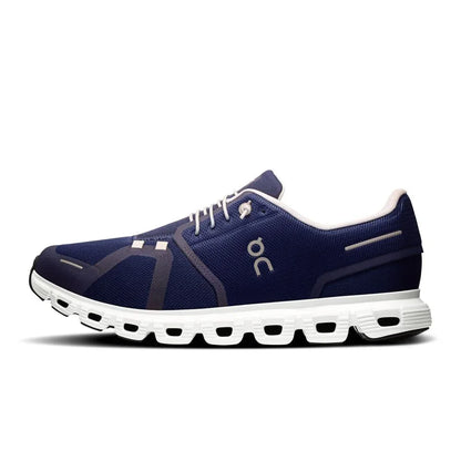 Tênis esportivo azul marinho com sola branca, design moderno e detalhes sintéticos laterais.