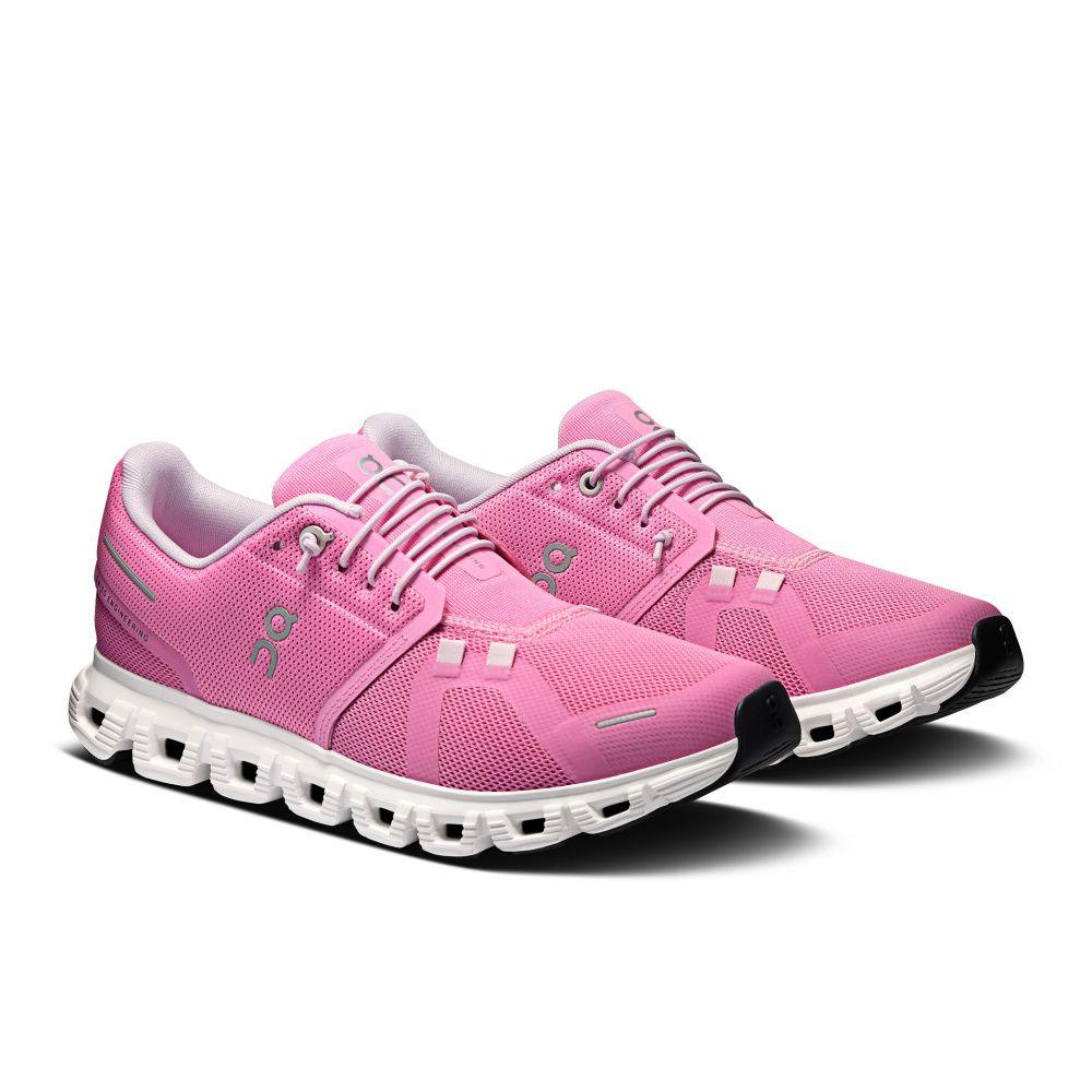 Tênis de corrida rosa com design moderno, solado branco e detalhes em mesh, visto de lado.