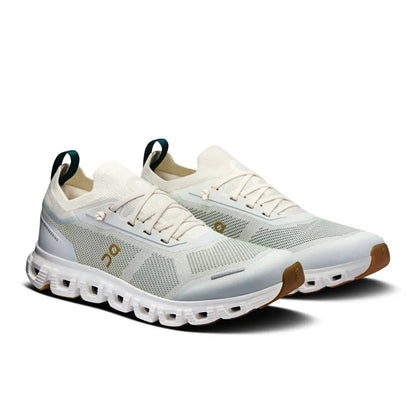 Tênis esportivo branco e verde On Running Cloud 6 Versa, com solado robusto e detalhes em mesh.
