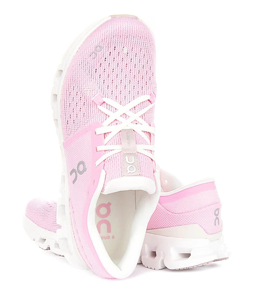 Tênis esportivo rosa On Running Cloud X4, com malha respirável e solado branco, vista superior e lateral