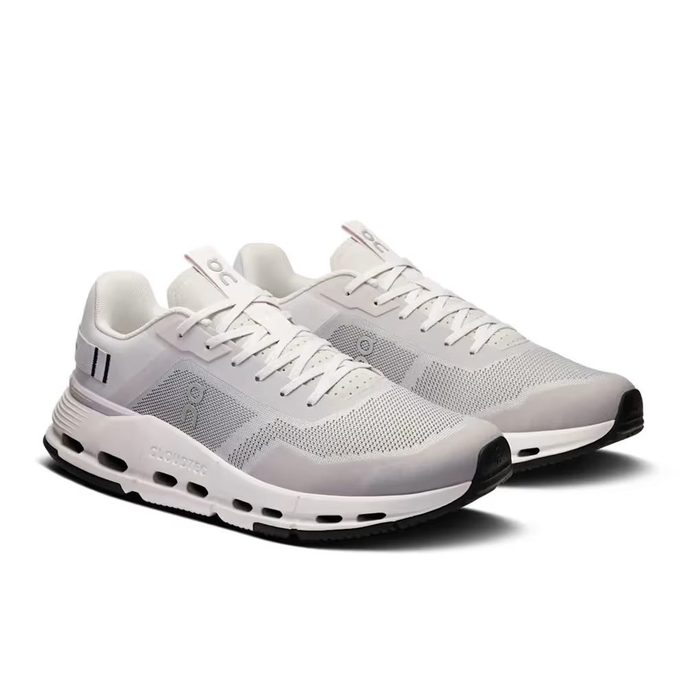 Tênis esportivo branco moderno com detalhes em cinza, sola robusta e design leve, visto de lado.