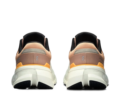 Tênis esportivo bege com detalhes laranja e branco, solado alto, visto de trás, modelo masculino