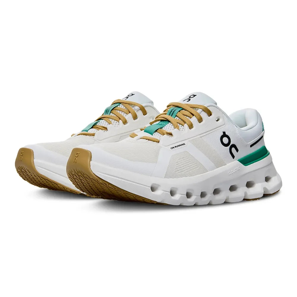 Tênis esportivo branco com detalhes verdes e caramelo, solado robusto, vista lateral.