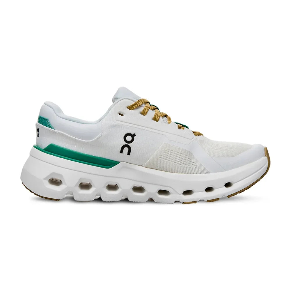 Tênis esportivo branco com detalhes verdes e solado robusto perfurado, lateral esquerda