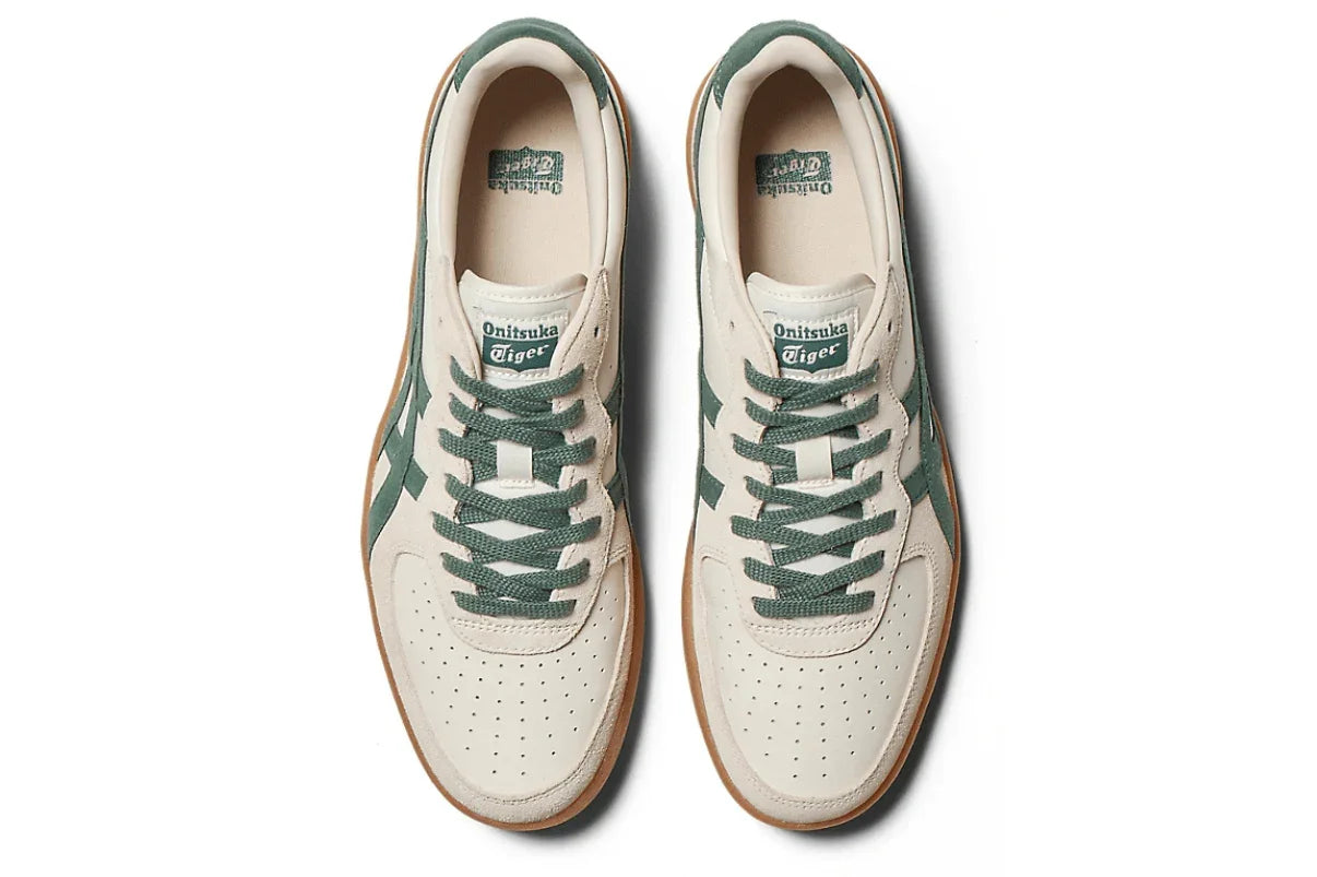 Tênis casual creme com detalhes verde musgo, sola marrom e logo visível na língua.