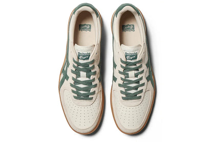 Tênis casual creme com detalhes verde musgo, sola marrom e logo visível na língua.