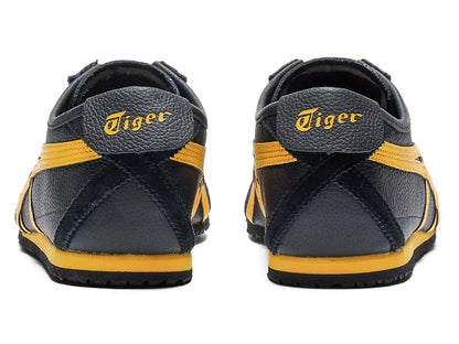 Tênis preto com detalhes amarelos, vistos de trás, com inscrição Tiger no calcanhar.