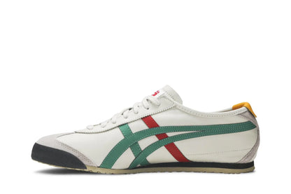 Tênis branco estilo retrô com detalhes em verde, vermelho e preto, sola baixa e detalhe amarelo no calcanhar.