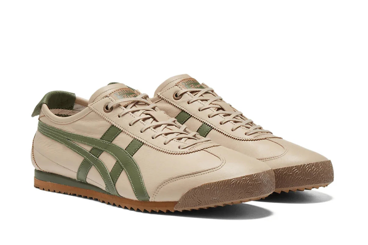 Tênis casual bege com detalhes verdes, solado em borracha, design retrô e listras laterais.