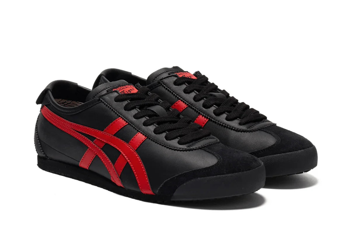 Tênis preto com detalhes vermelhos, modelo casual de couro, solado baixo, bico arredondado.