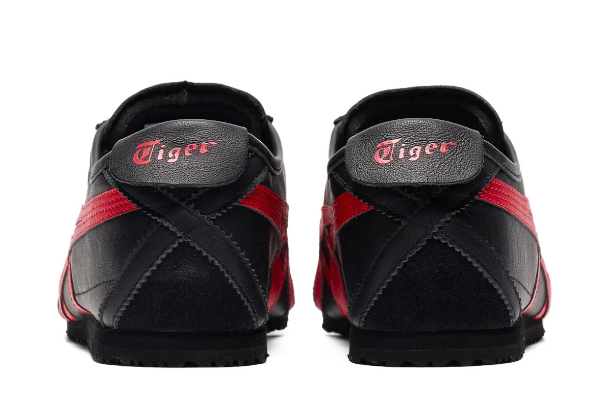 Tênis preto com detalhes vermelhos visto de trás, solado baixo e logo Tiger no calcanhar.