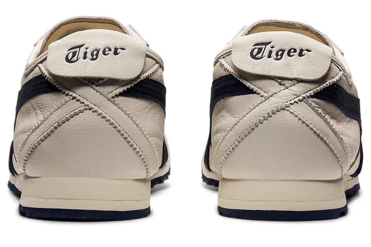 Tênis casual creme com detalhes azul marinho, vista traseira, solado emborrachado.