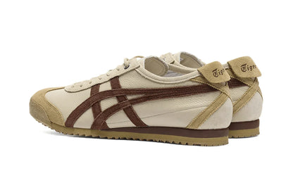 Tênis casual bege com detalhes marrons, material em couro e camurça, solado baixo e visual retrô.