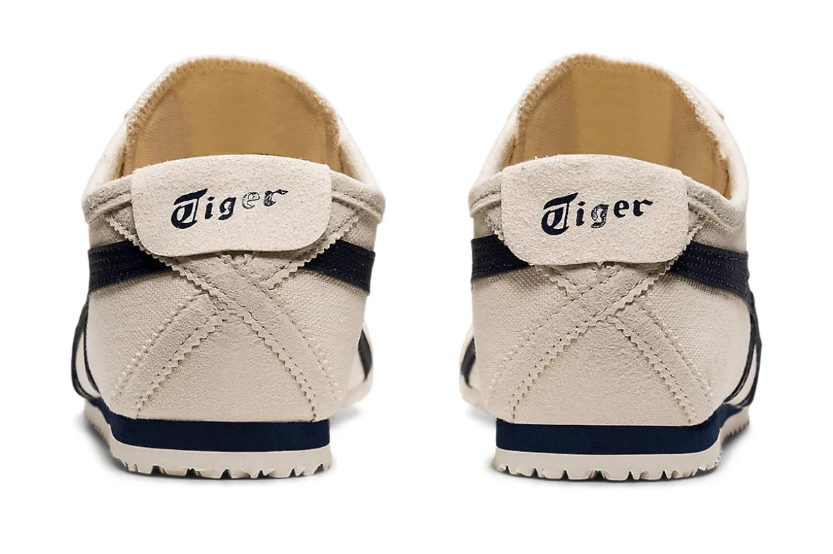 Tênis casual bege com detalhes em azul marinho, visto de trás, modelo slip-on, sola emborrachada.