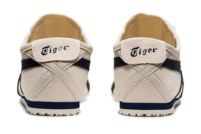 Tênis casual bege com detalhes em azul marinho, visto de trás, modelo slip-on, sola emborrachada.