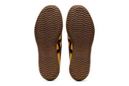 Solado do tênis amarelo com detalhes em preto, design ondulado e textura antiderrapante.