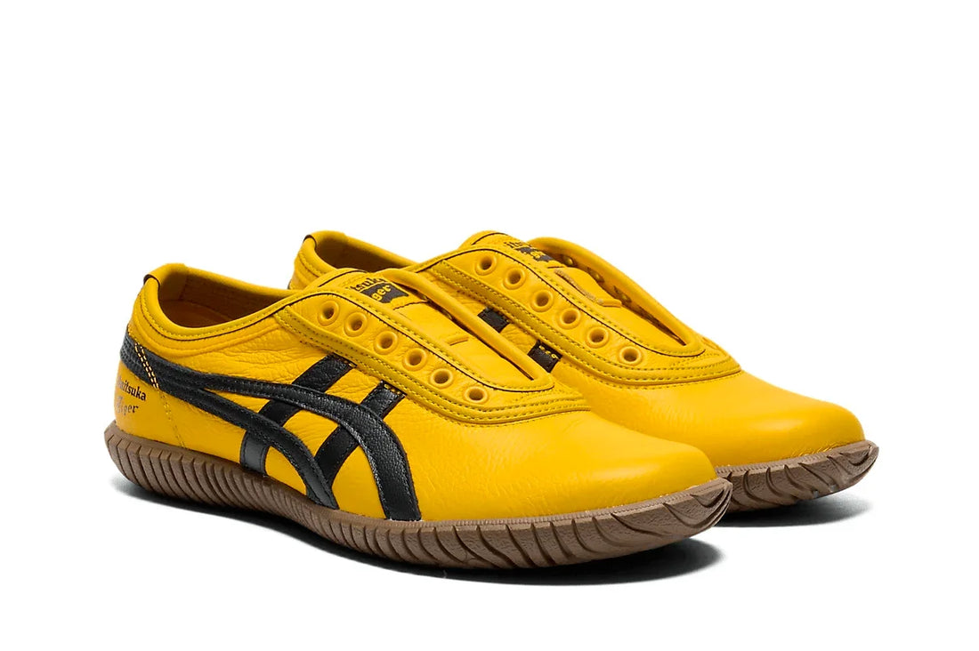 Tênis slip-on amarelo com detalhes pretos, solado de borracha, estilo esportivo e moderno.