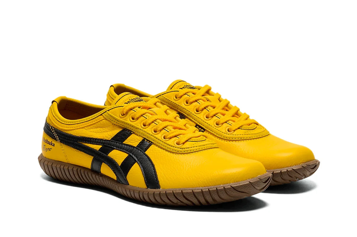 Tênis amarelo com detalhes pretos e sola marrom, estilo casual urbano, visual moderno.